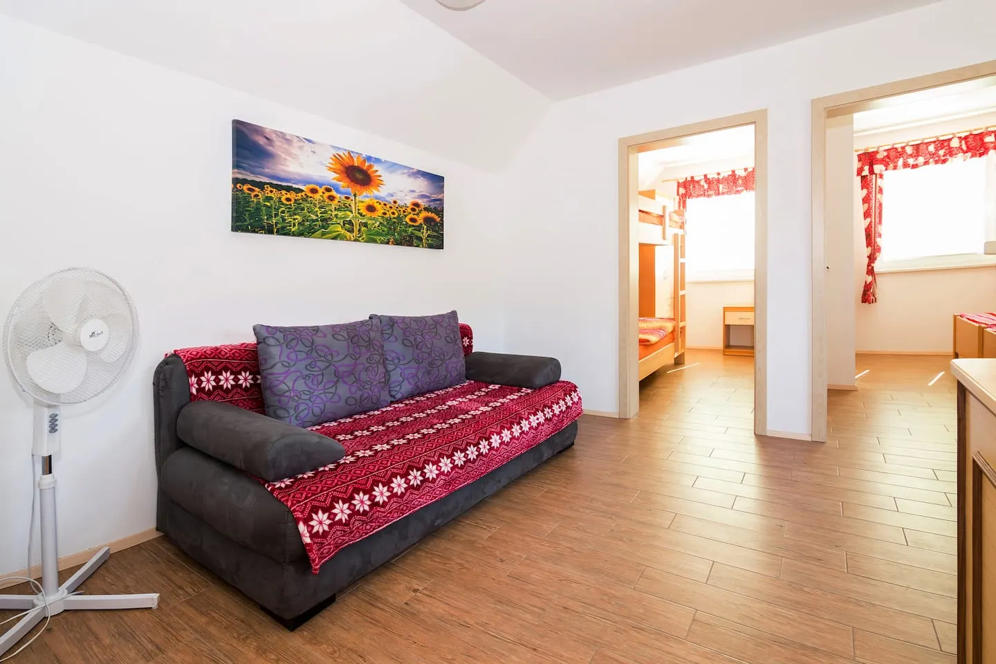 Rdeči apartma: kavč z rdečim pregrinjalom in pogled v spalnici