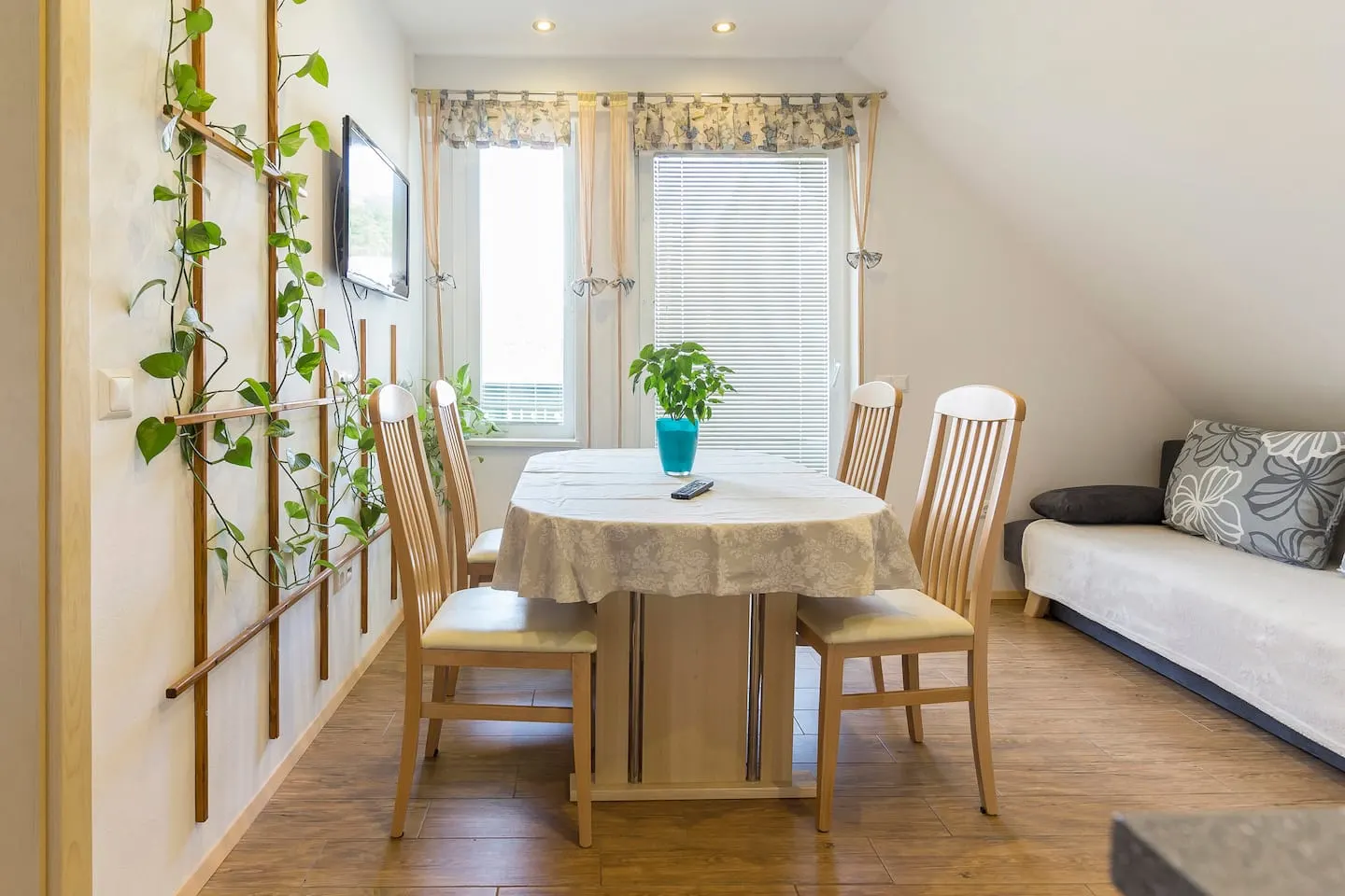 Zeleni apartma: jedilna miza ob oknu in rastline na steni